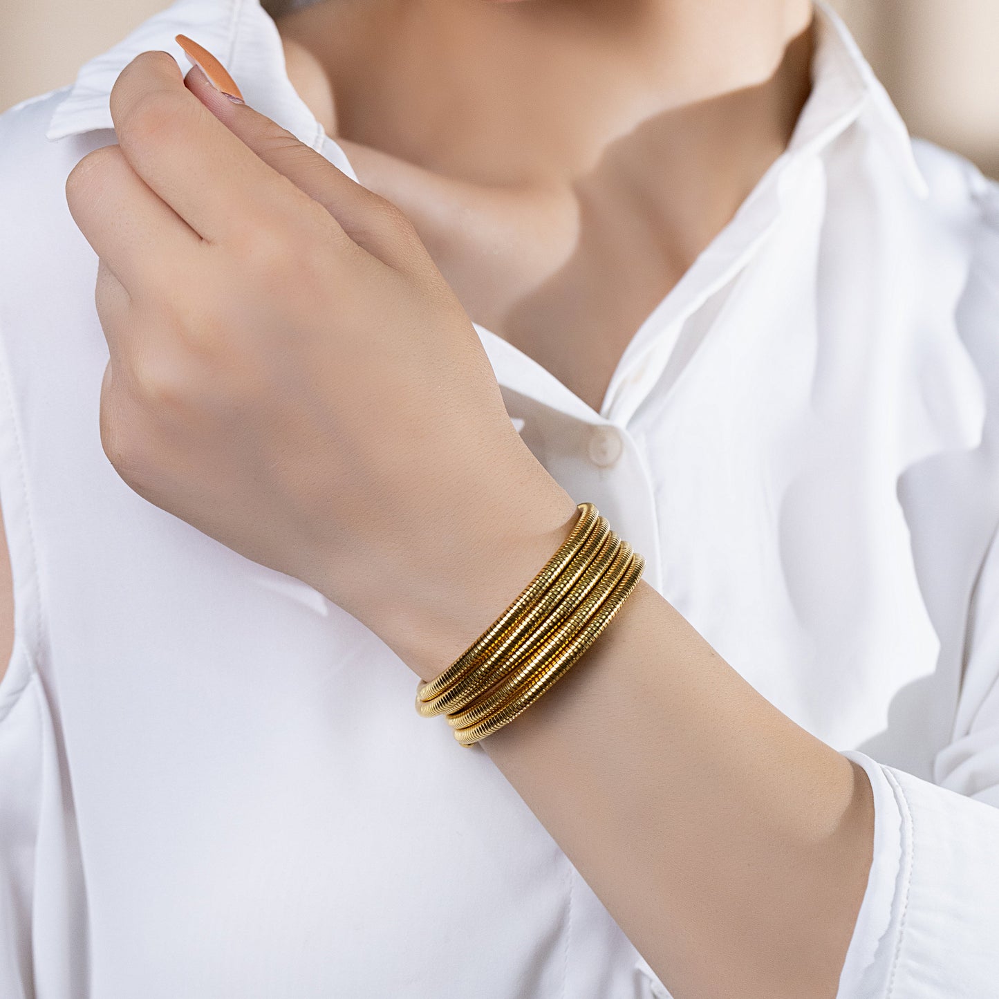 women wearing gold stackable bracelet