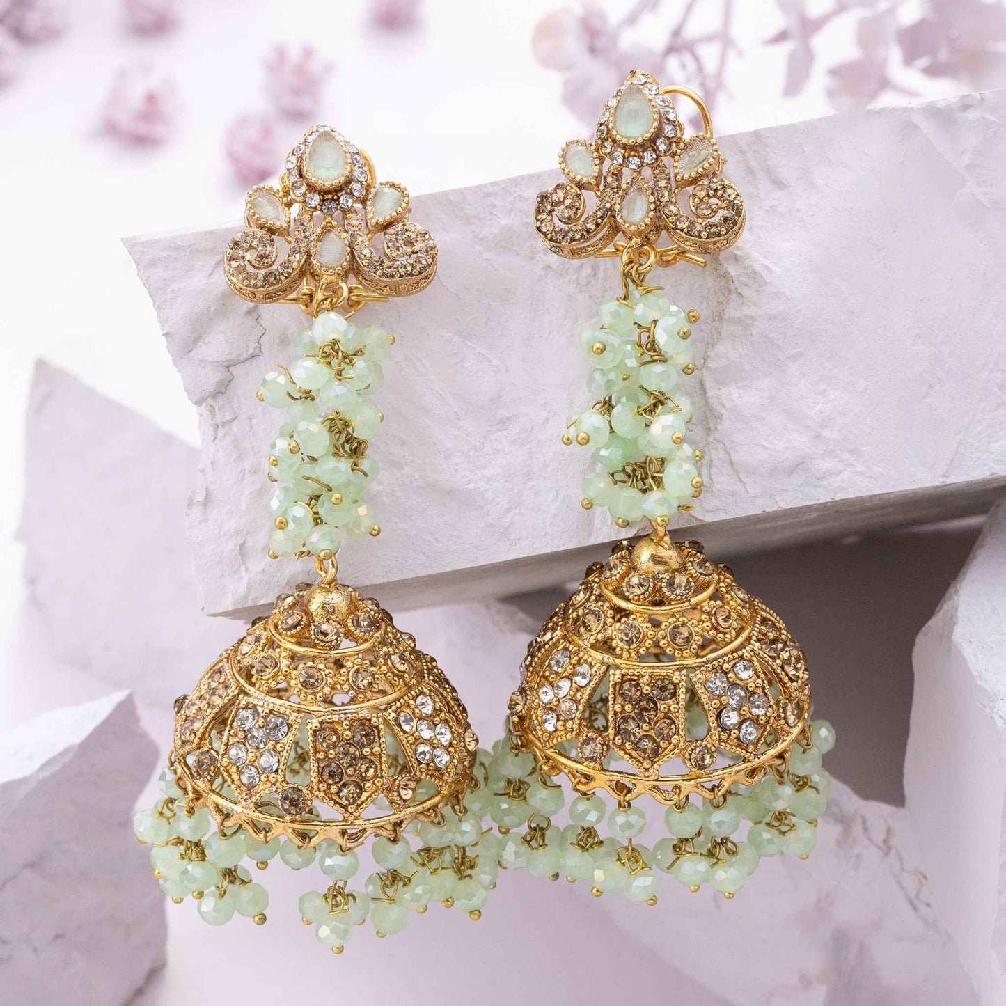 Gold jhumkas with pastel green stones and beads