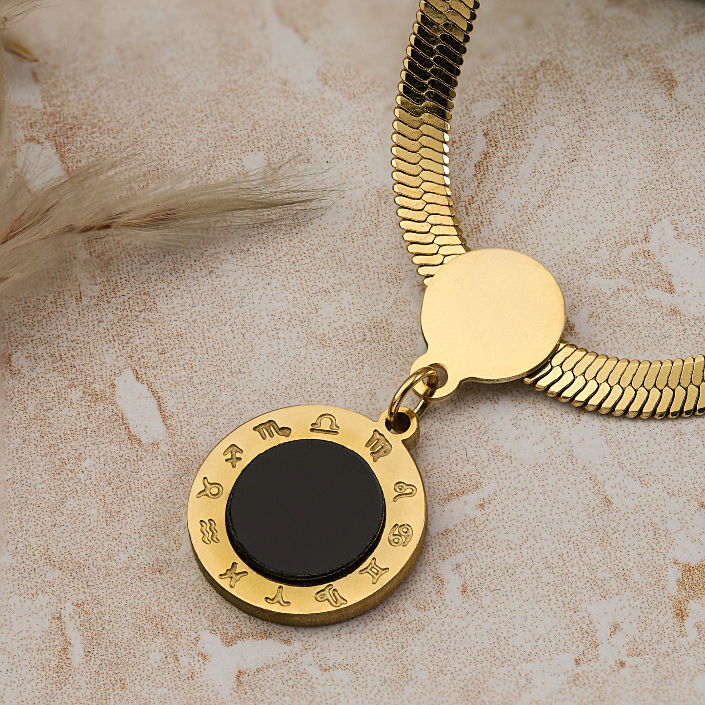 gold snake chain round black pendant