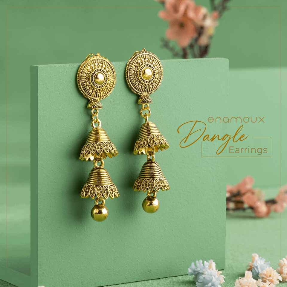 antique bell shaped dangle earrings on green background