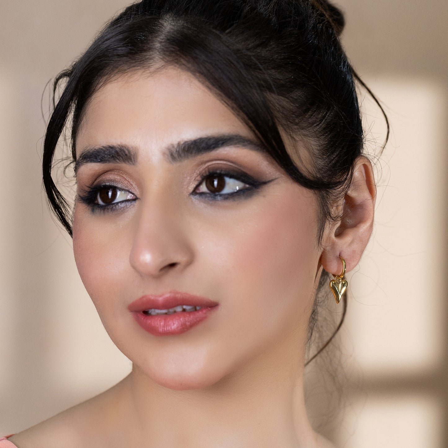 model wearing gold huggie earrings