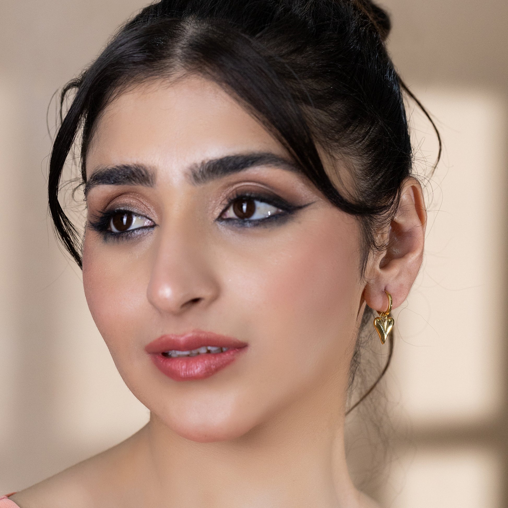 model wearing gold huggie earrings