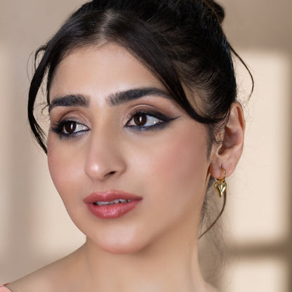 model wearing gold huggie earrings